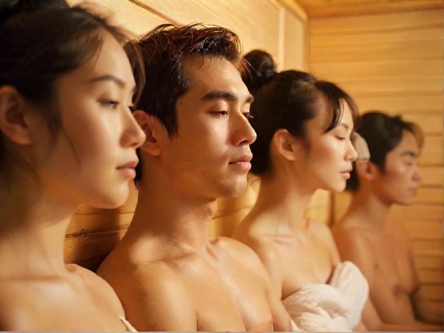 一位男士在温暖柔和的灯光下享受桑拿，神情放松